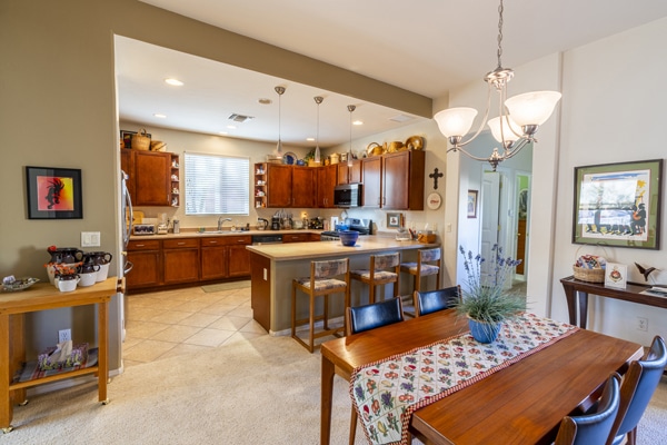 A real estate photo of a gorgeously furnished dining room and kitchen.